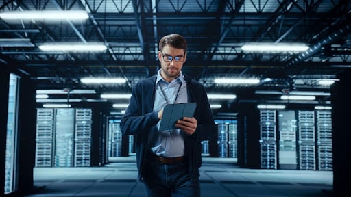 Homem em local corporativo mexendo no tablet